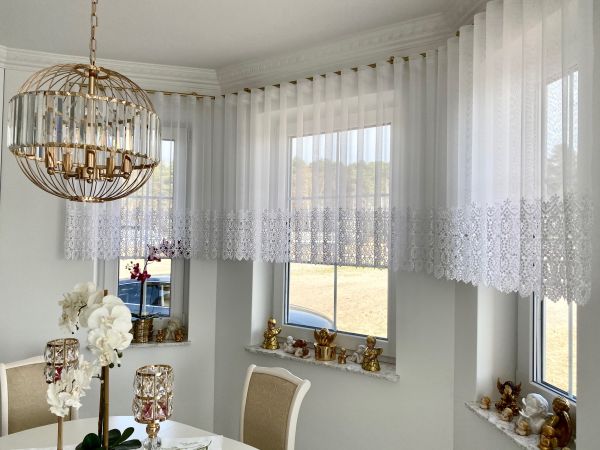 Vorhänge im Erkerfenster, unten mit Ornamenten verziert