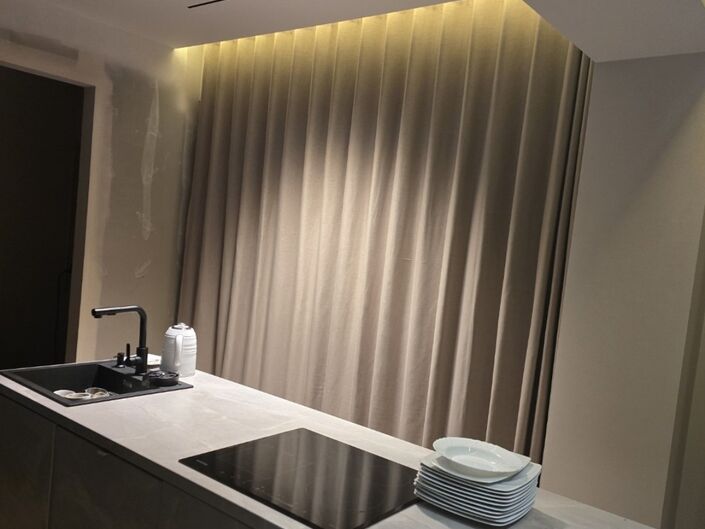 Elegantes Wohnzimmer, in dem grau-beige Vorhänge die Fenster komplett bedecken