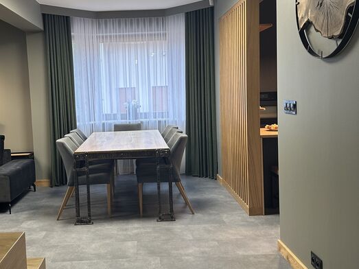 Modernes Wohnzimmer in Warm-Eukalyptus-Farben, ergänzt durch Vorhänge in Flaschengrün