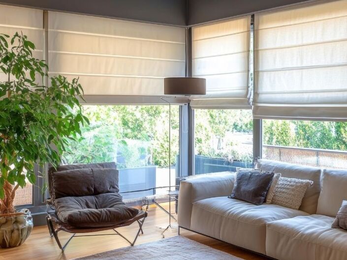 Modern gestaltetes Wohnzimmer, in dem Raffrollos in neutralen Farbtönen das Ambiente prägen